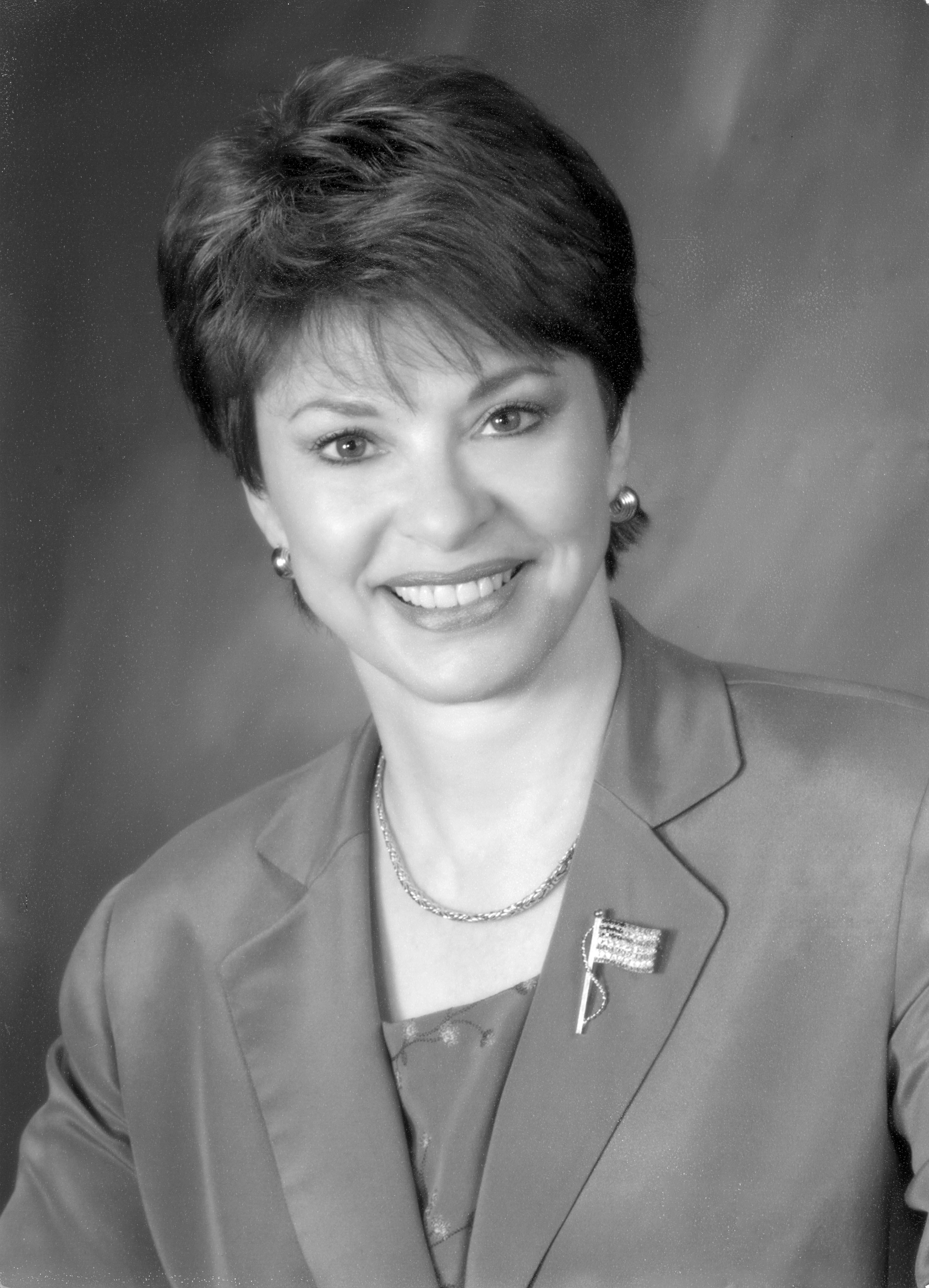 black and white portrait of a woman, wearing a suit jacket and american flag pin